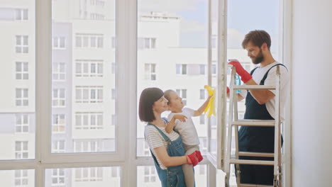 familia limpiando ventanas juntos