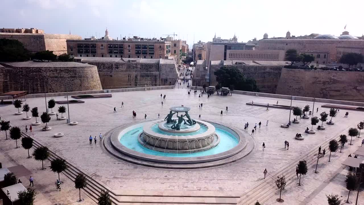 4K Aerial drone shot of Valletta,Malta. Flying above Triq Sarria,passing by palmtrees and the christ king statue, towards the Triton Fountain and city gate.