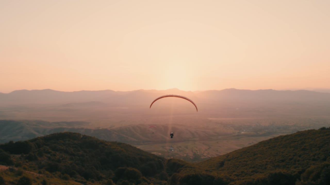 piloto de parapente volando directamente hacia el sol