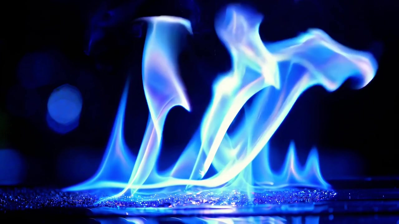 Fiamme blu vivaci che bruciano su una superficie riflettente