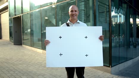 cheerful businessman holding a placard outside his office