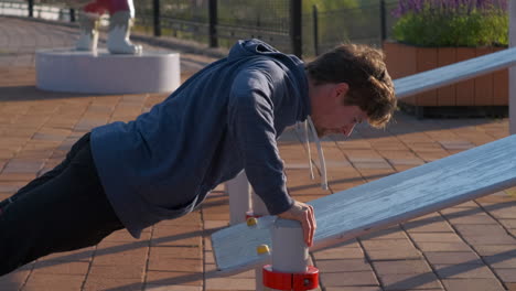 man doing push-ups at outdoor gym