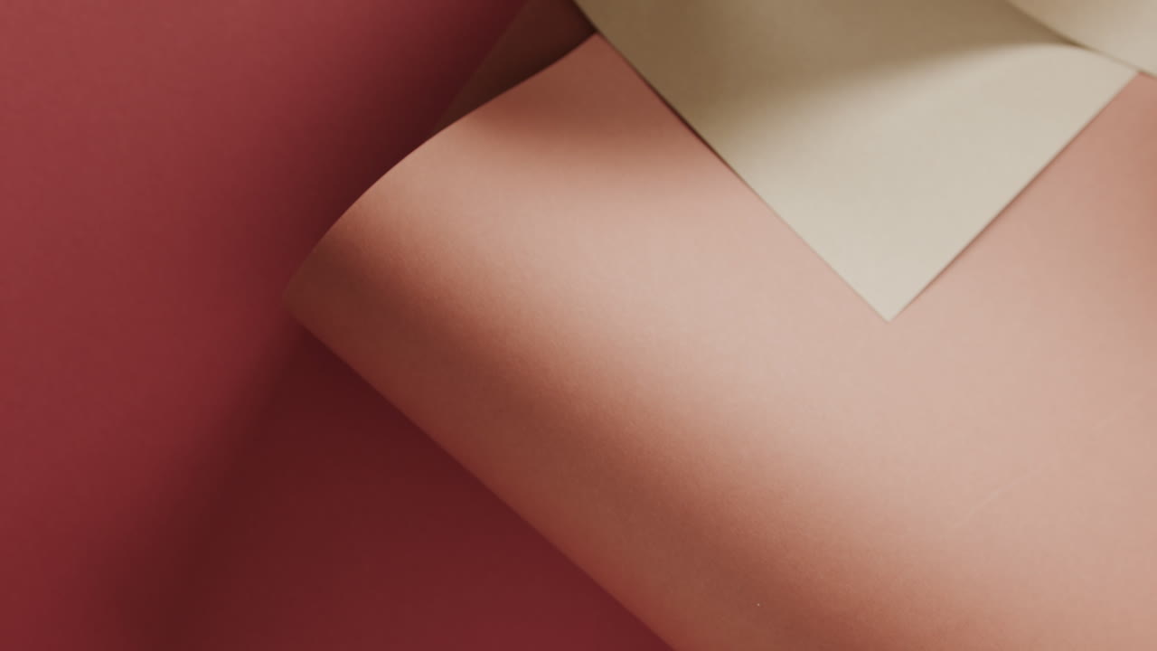 cerca de dos tonos de papeles enrollados marrones en fondo rojo con espacio de copia en cámara lenta