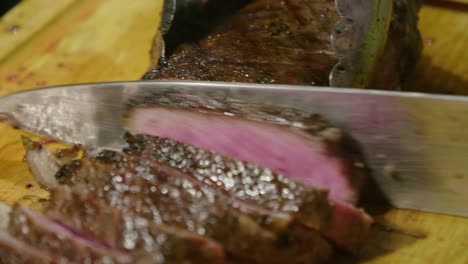 cutting grilled juicy steak on table