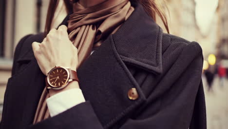 elegant woman in a coat and scarf with a watch