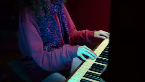 a serene holiday scene featuring a woman in a santa hat playing soft christmas melodies on the piano under festive lights.