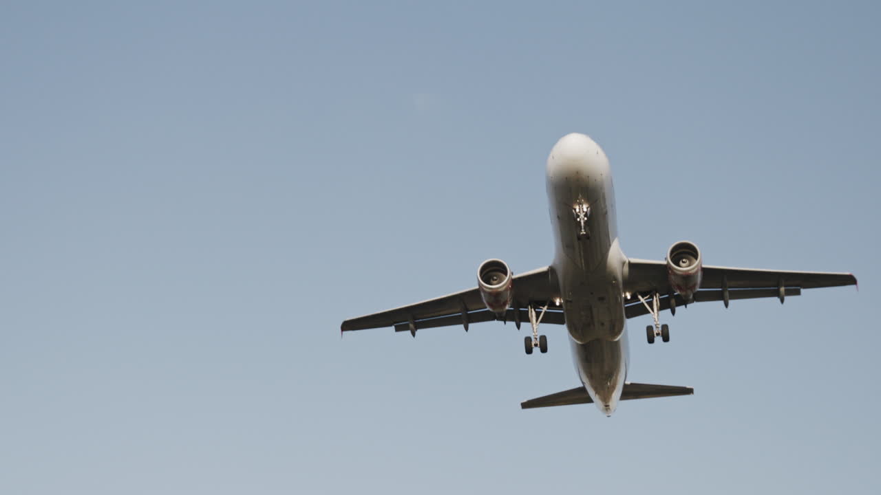 Avión volando en el cielo para aterrizar en el aeropuerto a cámara superlenta al atardecer