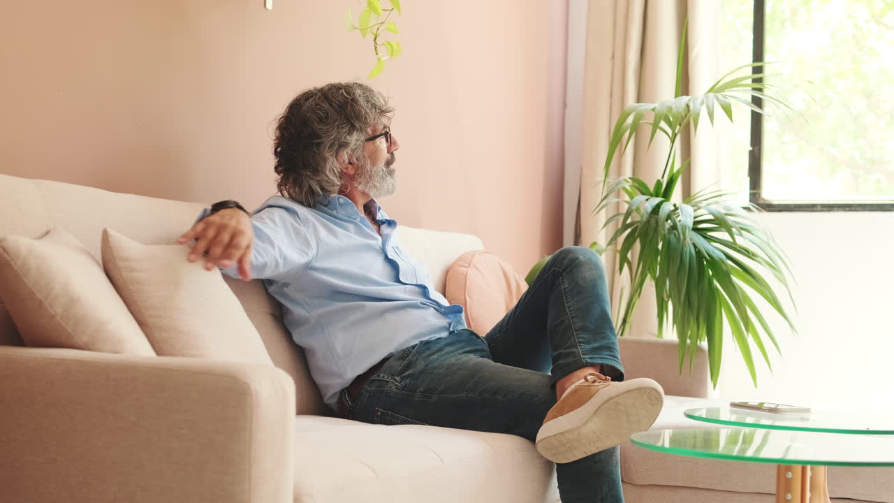 Relaxed Mature Man Sitting on Sofa in Cozy Living Room