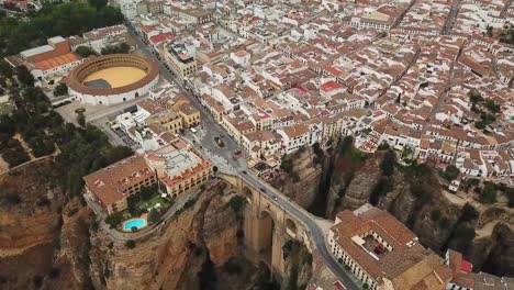 a breathtaking aerial perspective of ronda, spain, highlighting the iconic puente nuevo bridge spanning a deep gorge, traditional buildings, and the circular bullring amidst the picturesque landscape