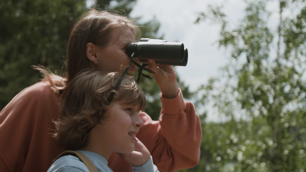 Mother and Son Observing Nature with Binoculars