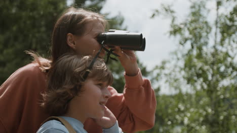 mother and son observing nature with binoculars