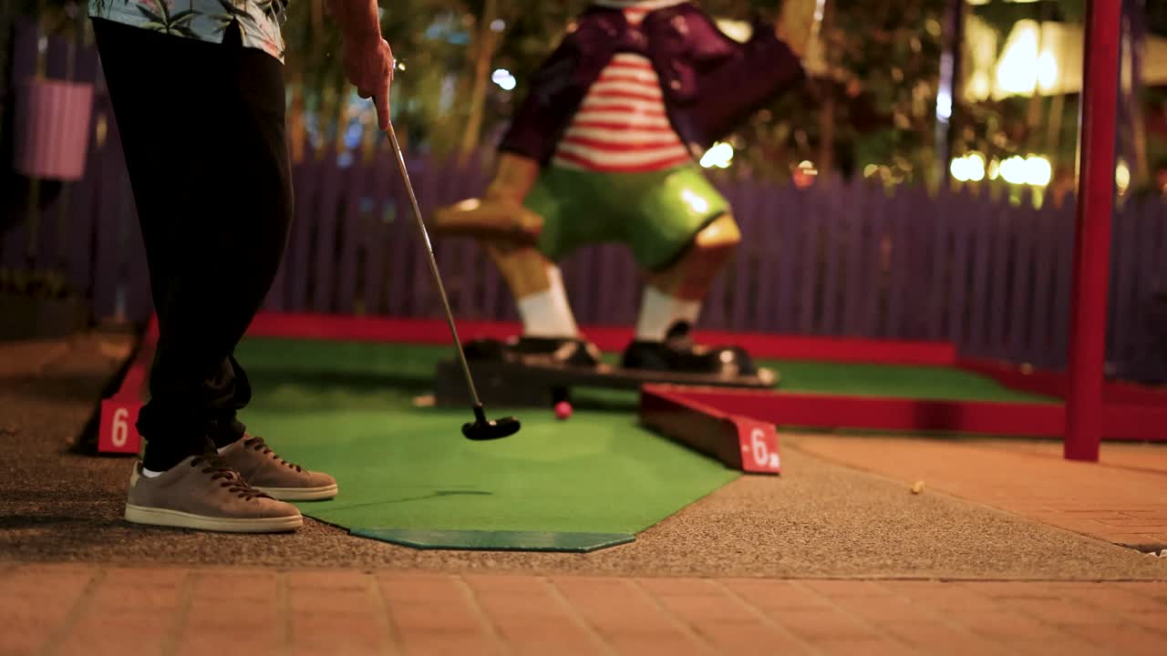 A lively scene of kids playing miniature golf in a vibrant, tropical-themed environment with colorful lighting