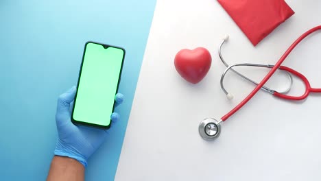 profesional médico con teléfono inteligente y estetoscopio