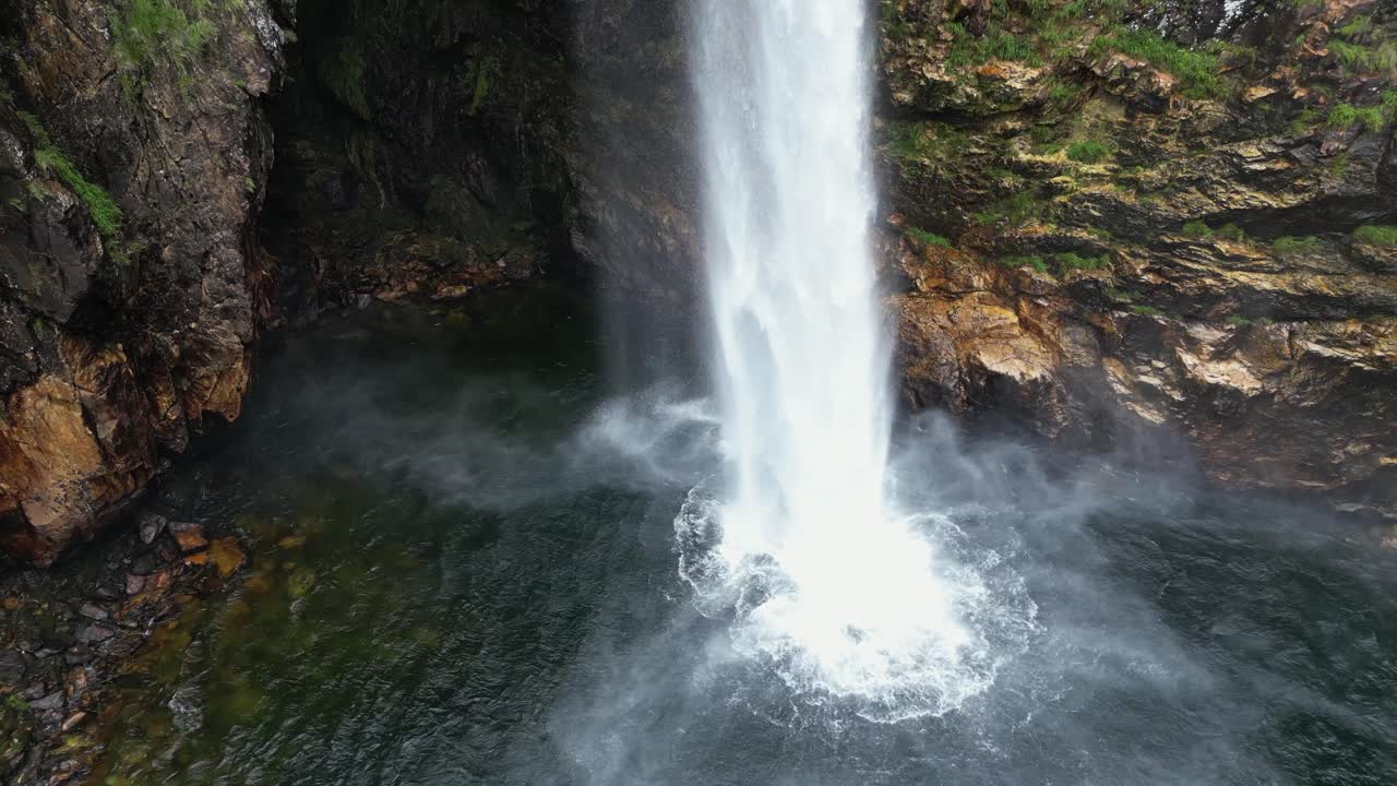 Fundao waterfall throws mist as it thunders into shallow pool below