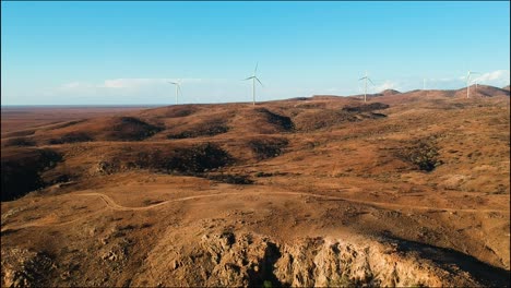 Torres-De-Parques-Eólicos-Se-Elevan-Majestuosamente-Sobre-El-árido-Paisaje-Desértico