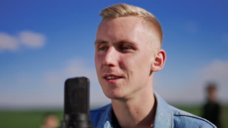 man singing into microphone outdoors