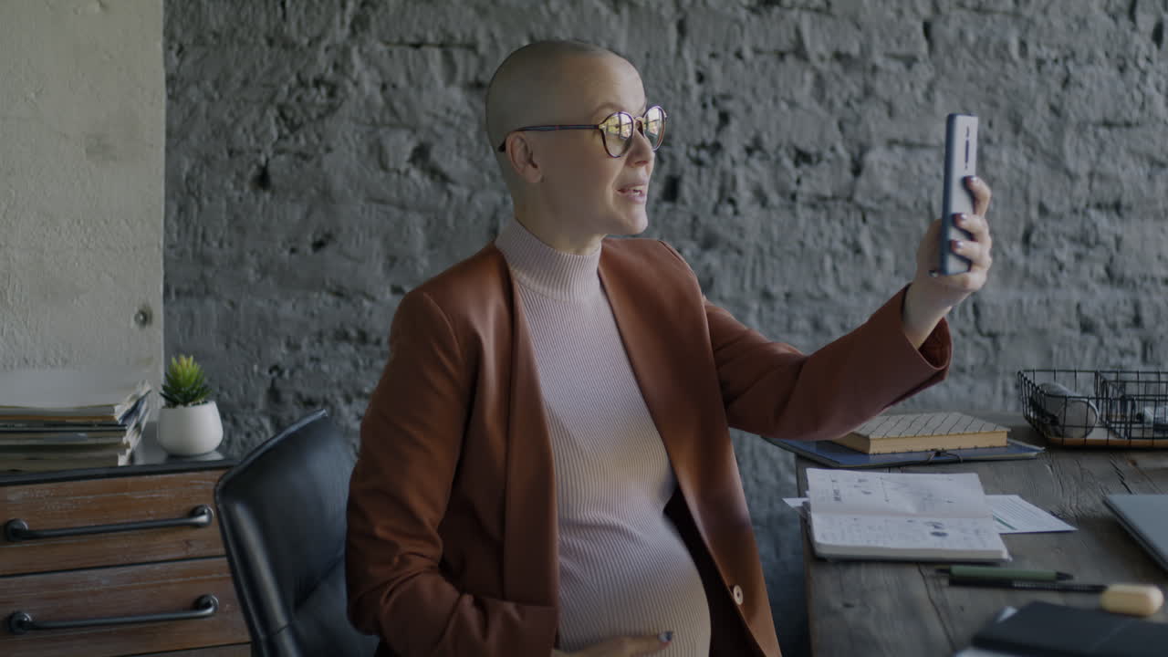 Pregnant businesswoman having a video call in the office