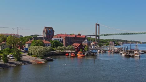 view of alvsborg bridge across gota river near klippan in gothenburg, sweden with boats and waterfront buildings at daytime