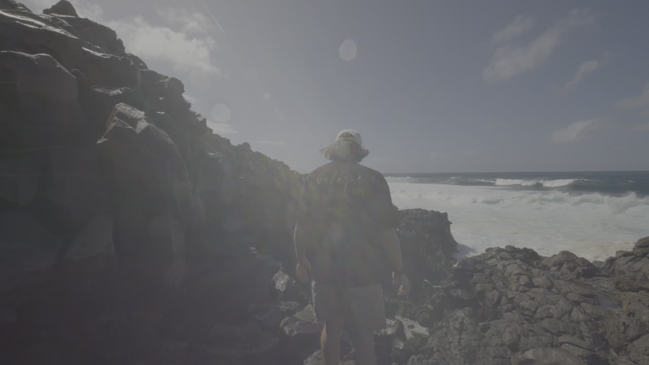 Man Hiking at Rocky Coastline with Waves