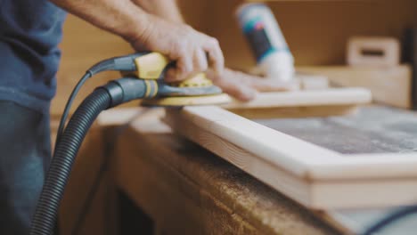 carpenter using ergonomic handled wood polisher to polish a woodwork