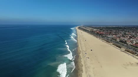 Vista-Muy-Alta-Sobre-Huntington-Beach-Casi-Sin-Gente-Y-Algunas-Olas-Grandes-Rompiendo-En-La-Orilla