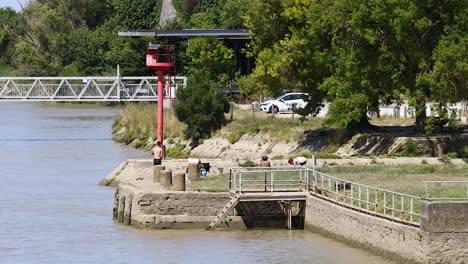 people relaxing and walking by the river