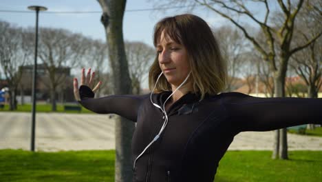 Chica-Deportiva-Enfocada-En-Auriculares-Haciendo-Ejercicio-En-El-Parque