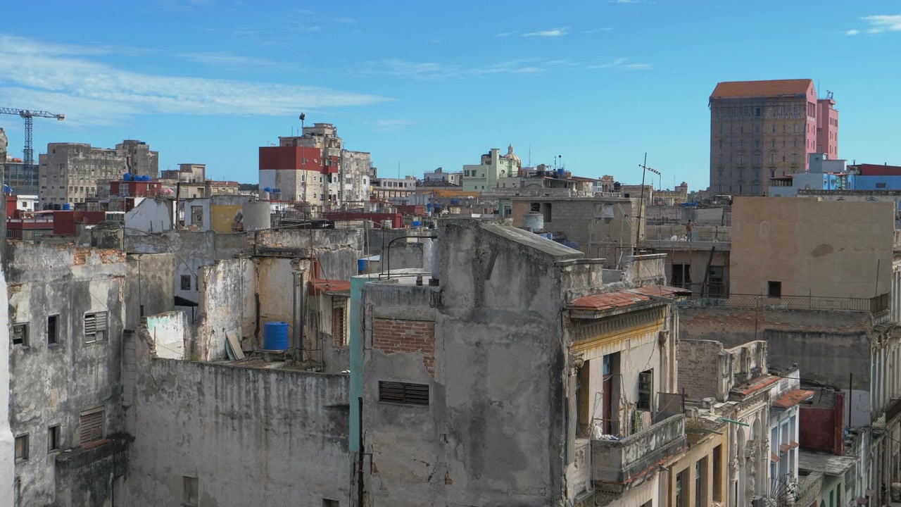 Panorama mostra lo skyline dei tetti dell'Avana, Cuba, con muri rovinati, balconi, gru edili, cielo azzurro brillante e strati densi della città vecchia per contenuti di viaggio all'aperto.