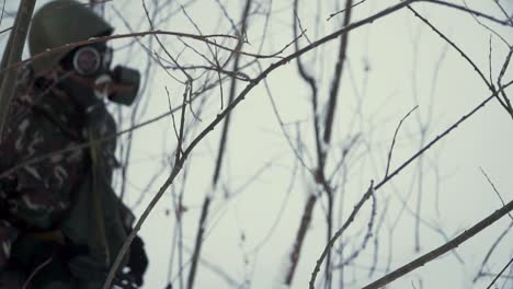 soldiers in winter camouflage gear with gas masks in a snowy environment