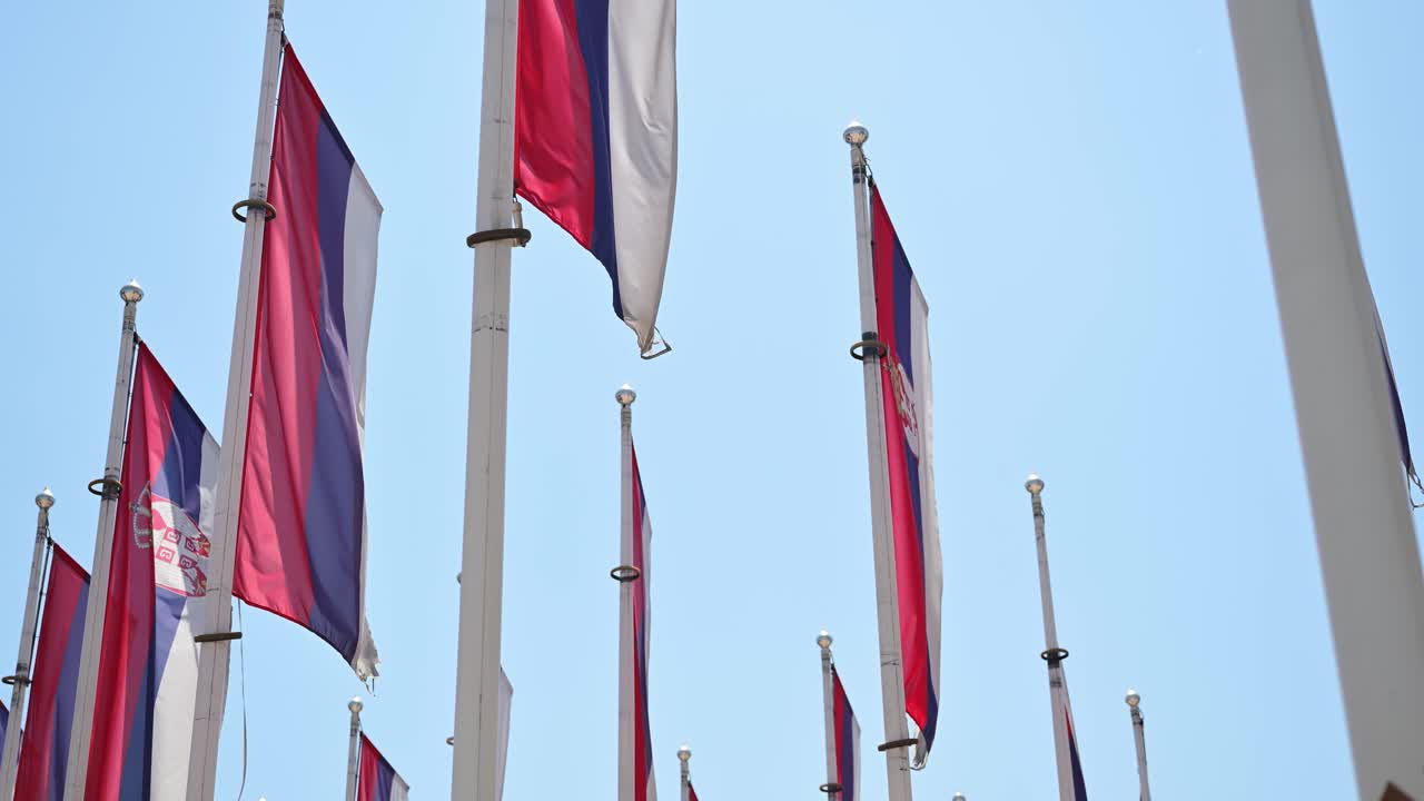 Serbian flags flapping in hot summer breeze, 4K selective focus