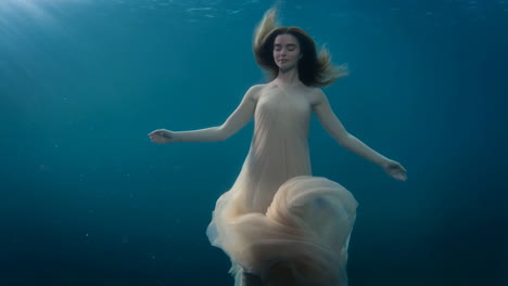 woman in a flowing dress underwater
