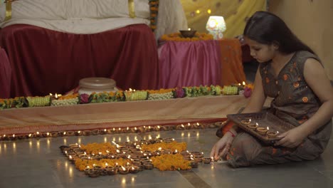 indian girl lighting diyas