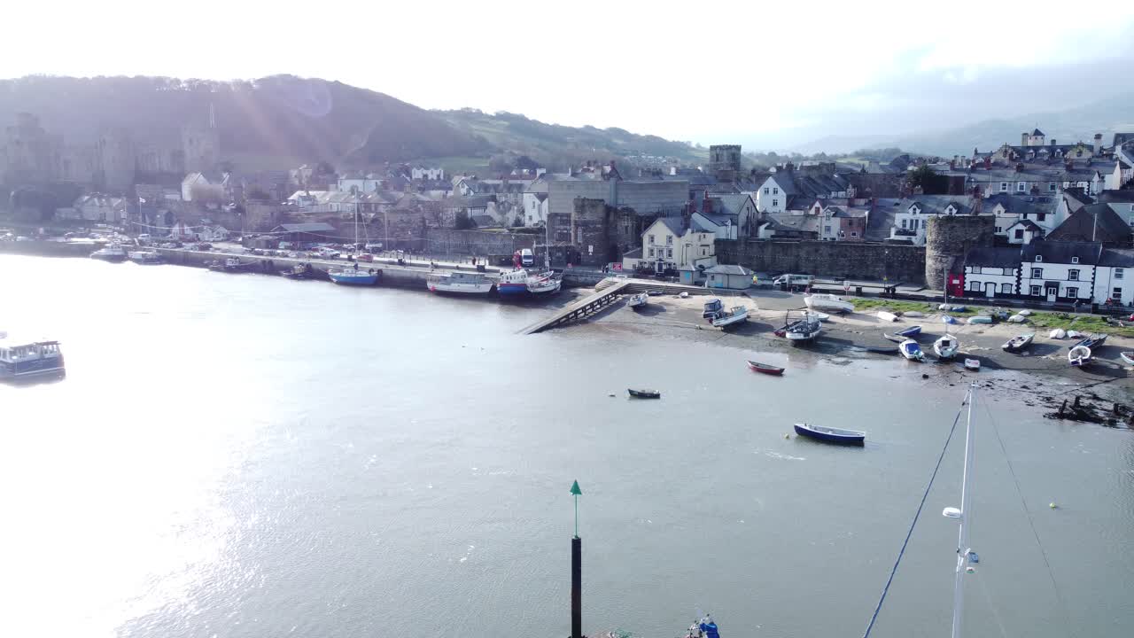el idílico castillo de conwy y el puerto de la ciudad pesquera se alejan rápidamente de la antena costera frente al mar