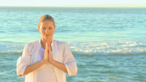 Blonde-Frau-In-Weiß-Macht-Yoga-Am-Strand