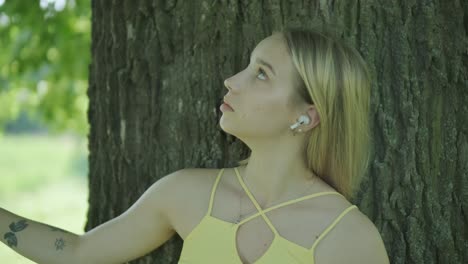 feliz joven hermosa bailando de libertad en el parque de verano con árboles en el fondo.