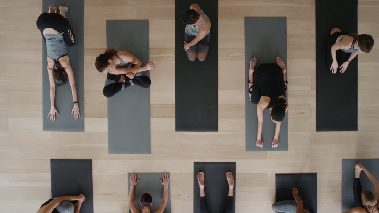 보기 위의 요가 수업 건강한 여성들이 피트니스 라이프스타일을 즐기는 스튜디오에서 운동을 준비하며 스트레칭을 하고 있습니다.