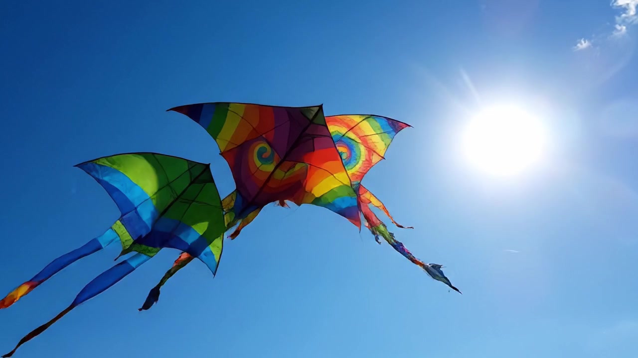 Pipas coloridas voando alto em um céu azul brilhante: Uma celebração de designs vibrantes e a alegria de empinar pipa em um dia ensolarado.