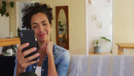 Mujer-Caucásica-Usando-Un-Teléfono-Inteligente-En-Videollamada,-Sentada-En-Un-Sofá-En-Casa