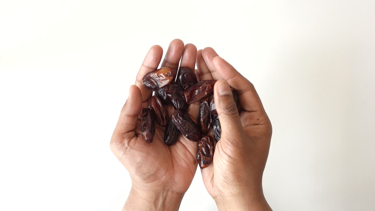 Top view of many date fruit on hand on white background