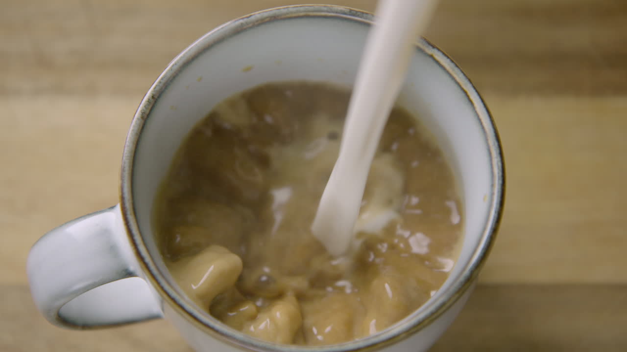 150fps SLOW MOTION latte d'avena schiumoso che si versa per fare il cappuccino.
