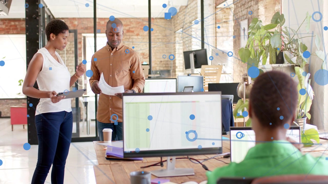 Vertical video: Woman tapping tablet, man reading docs for office task, blue dots moving over desk