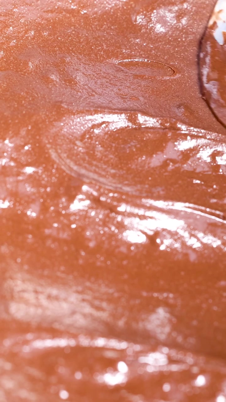 Cucchiaio che mescola cioccolato fuso per una consistenza liscia