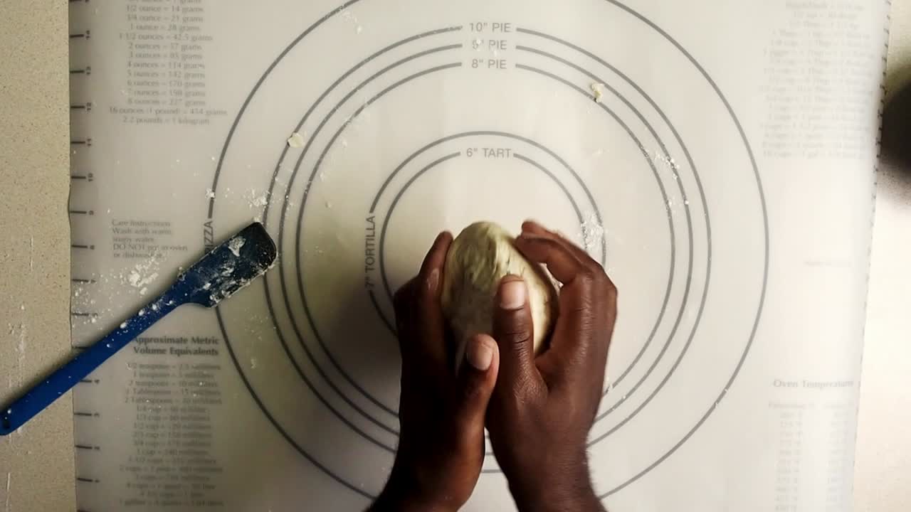 Overhead view of hands kneading the dough.