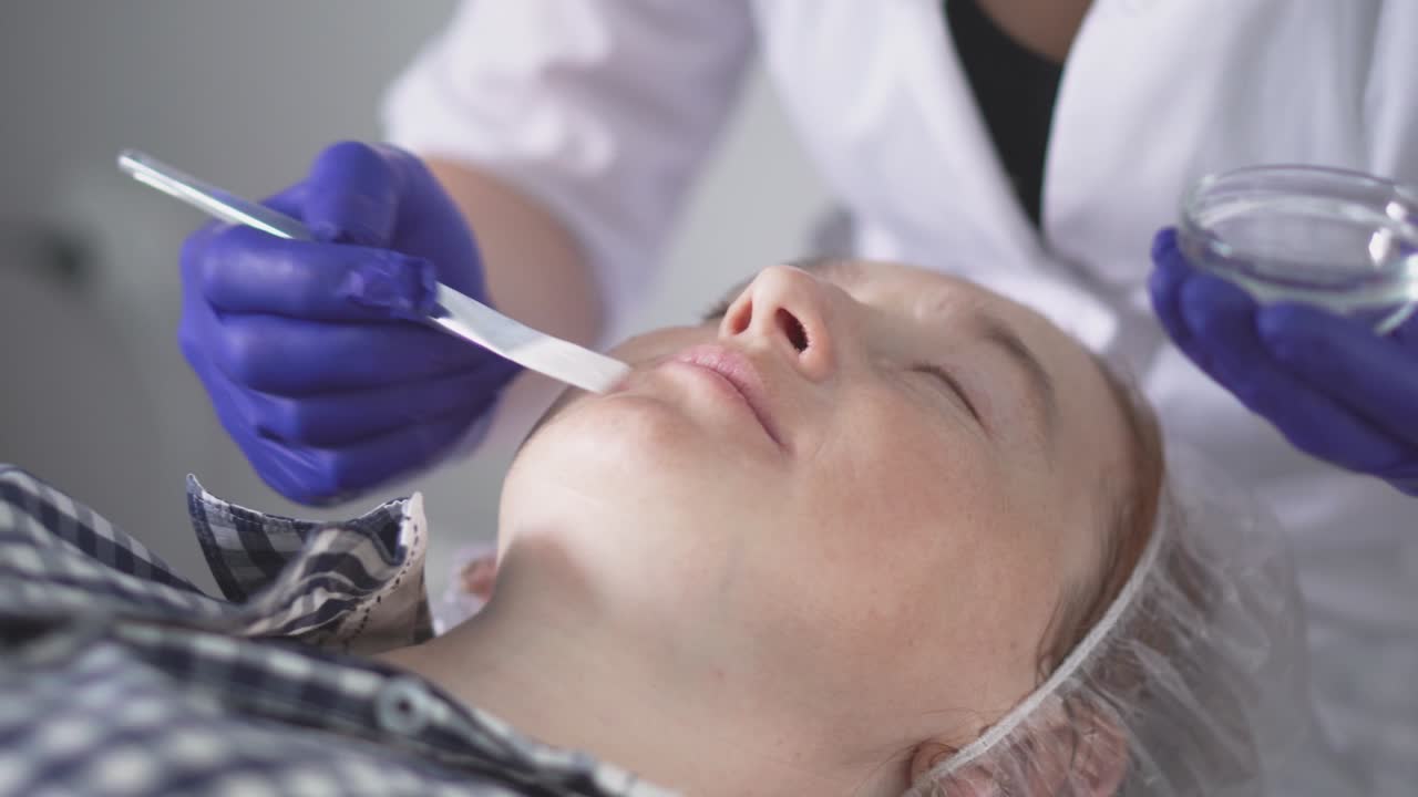 Apparaturbehandling inden for kosmetologi. Peeling, fonoforesis, massage og ansigtsløftning på en skønhedsklinik. Kosmetolog udglatter rynker med mikrostrøm.