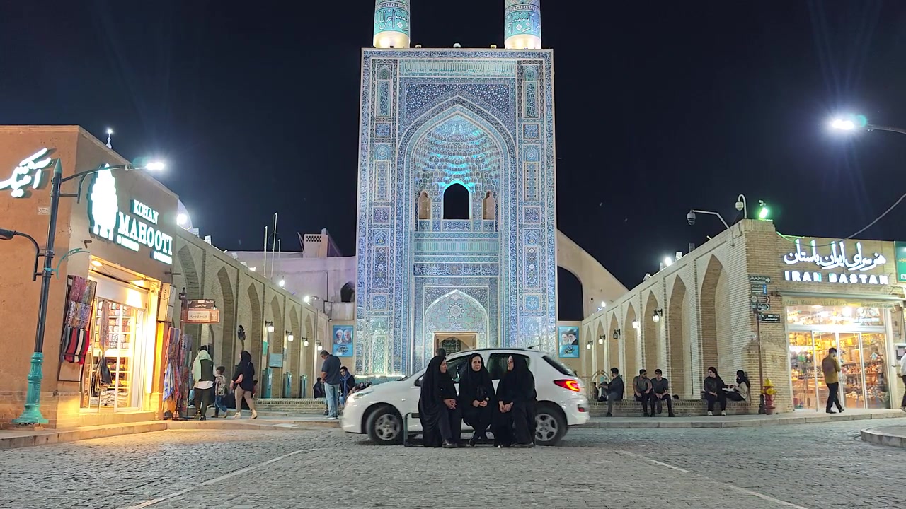 Gece Aydınlatılmış Cami Önünde Oturan İnsanlar