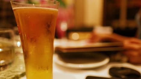 a relaxing dining scene with a focus on a frosty beer glass, warm lighting, and casual atmosphere