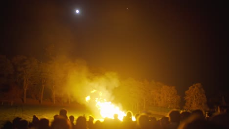 Gente-Reunida-Alrededor-Del-Fuego-En-La-Oscuridad-Durante-La-Luna-Llena