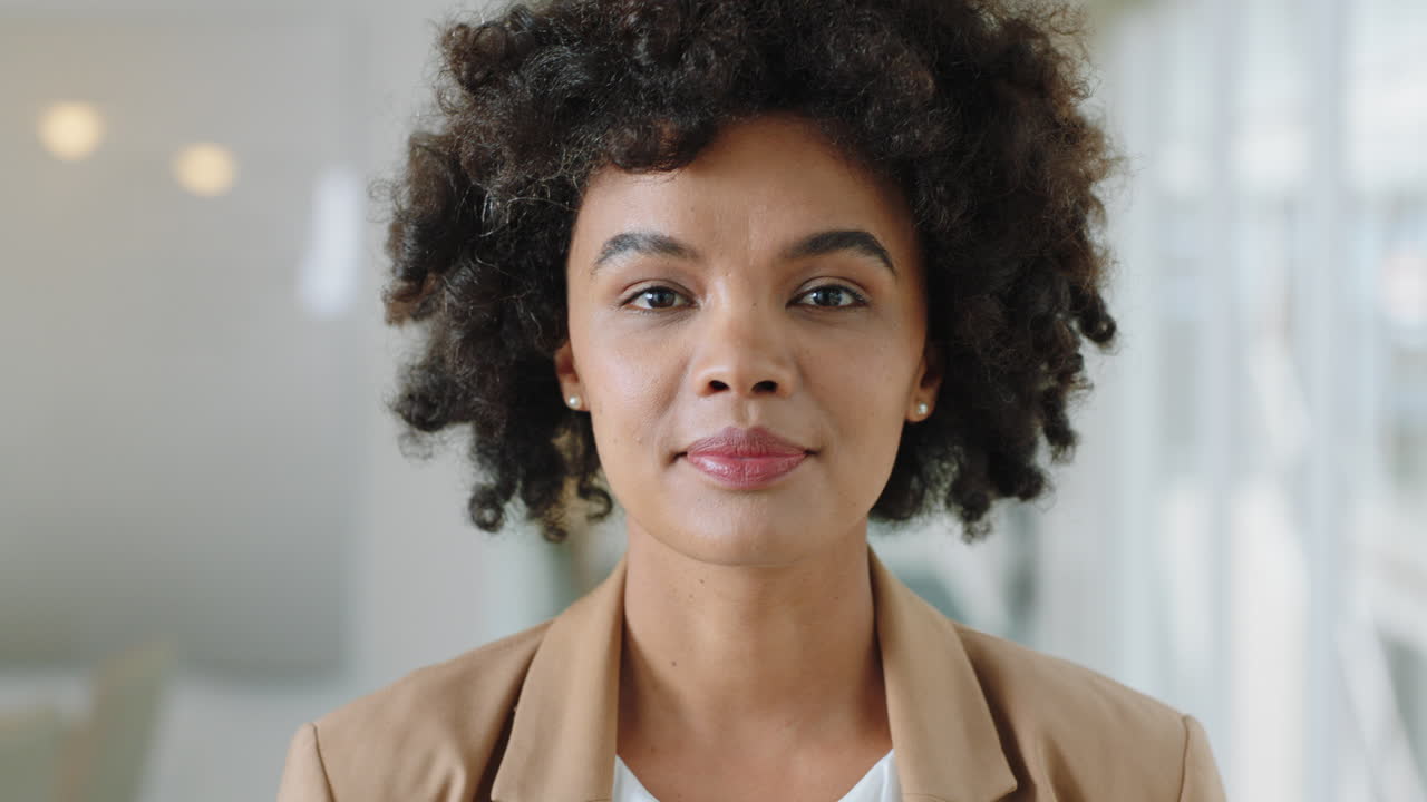 retrato feliz mujer de negocios con afro sonriendo disfrutando de una carrera exitosa orgullosa empresaria en la oficina lugar de trabajo testimonio 4k metraje