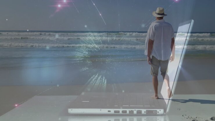 Man walking on beach with digital network animation over laptop
