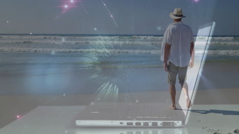 man walking on beach with digital network animation over laptop